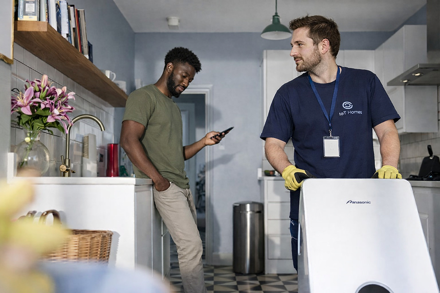 Engineer fixing sink in modern kitchen