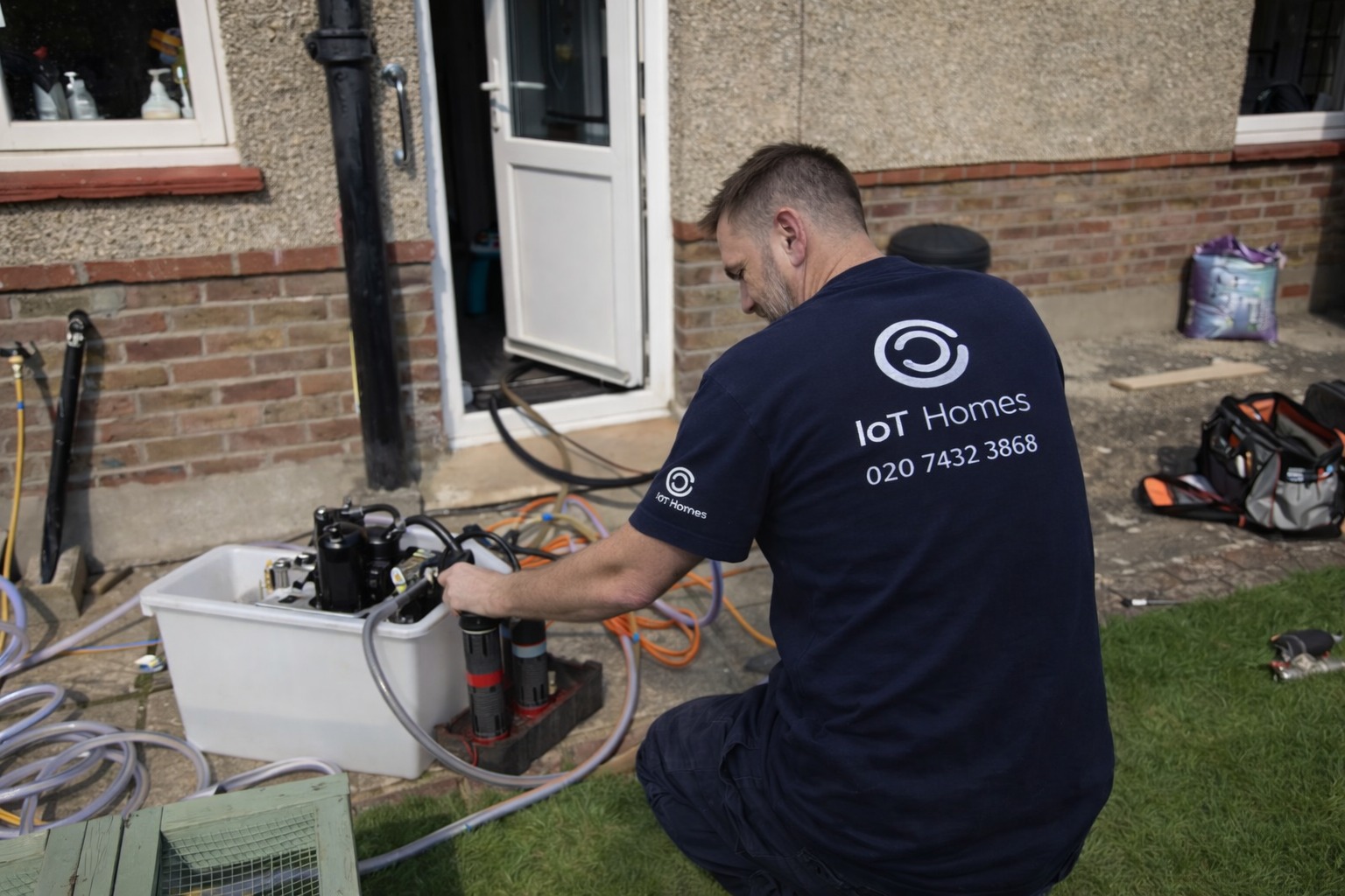 Engineer fixing sink in modern kitchen
