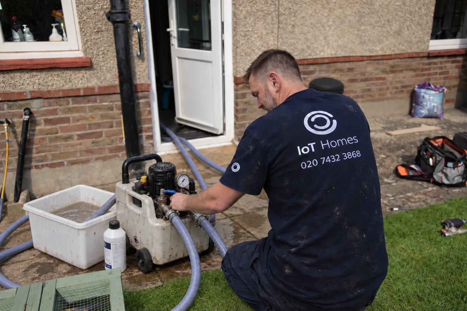 An IOT Homes engineer running a power flush on a heating system