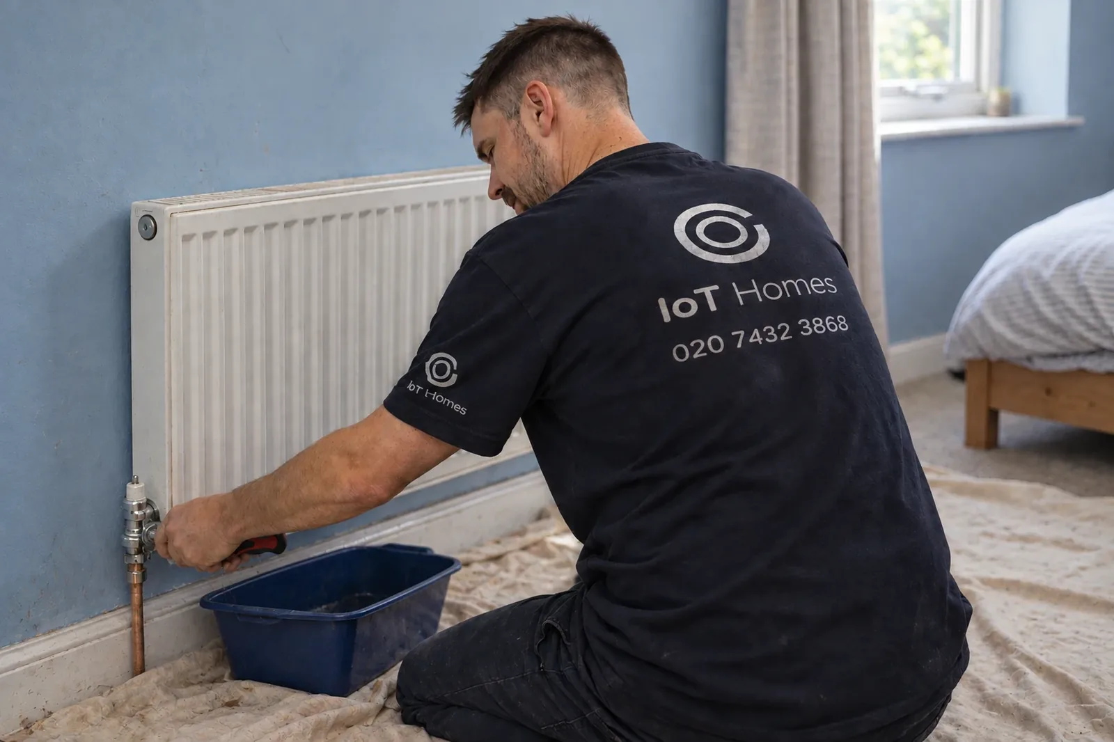 An IOT Homes engineer working on a radiator valve